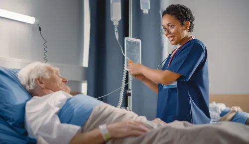 Nurse Making Rounds does Checkup on Elderly Patient Resting in Bed