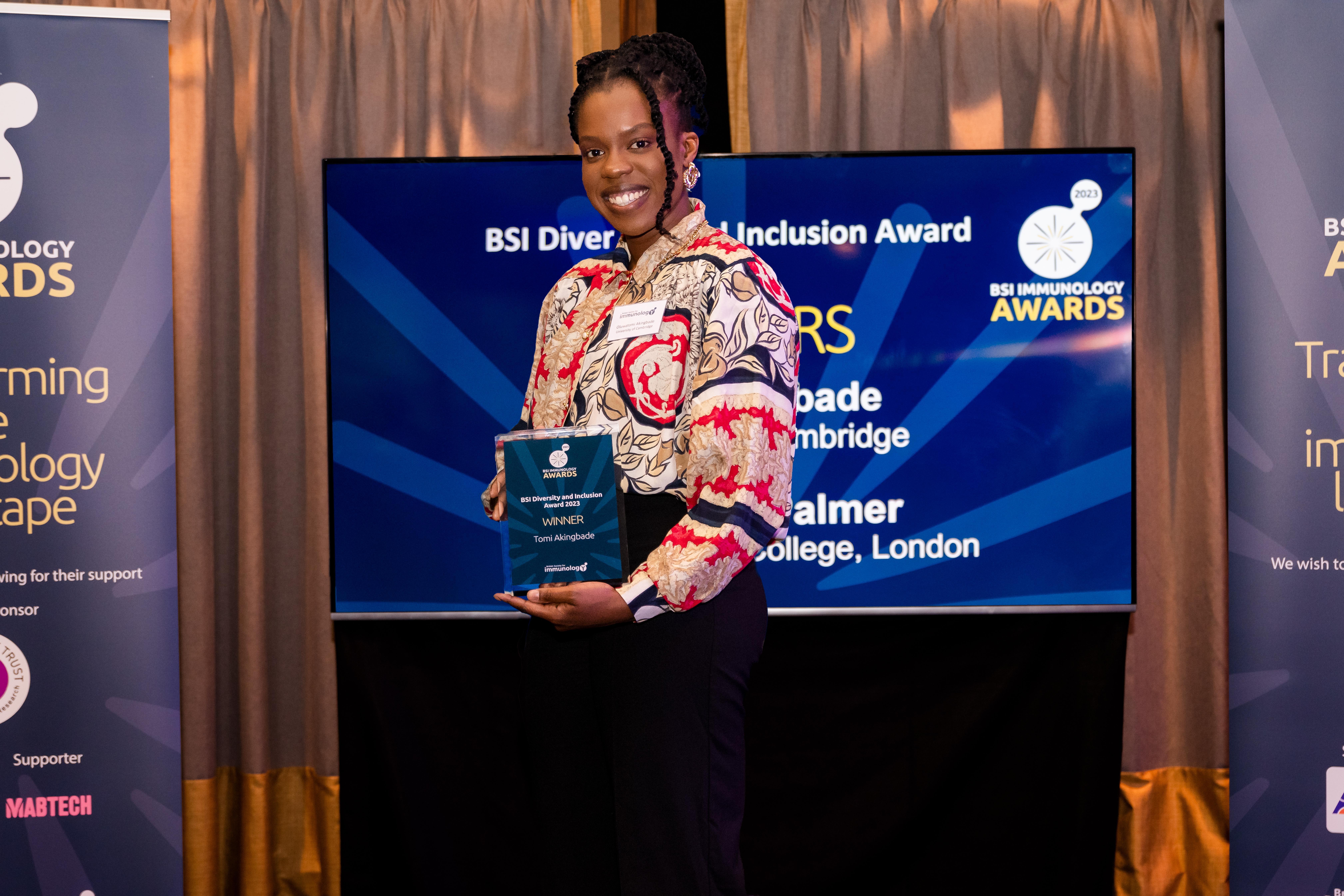 Tomi Akingbade holding her award