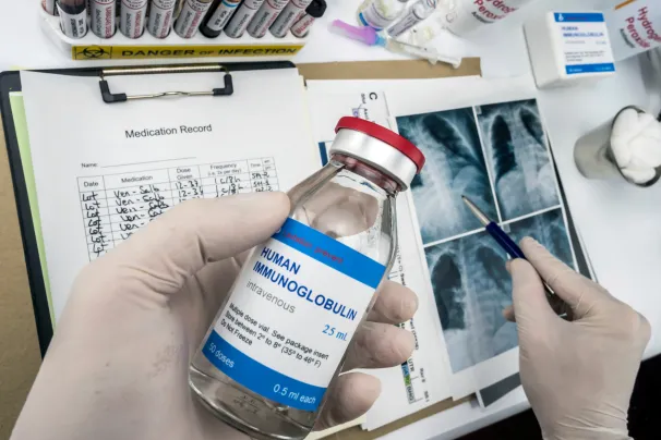 Clinician in lab holding immunoglobulin product for immunodeficiency 