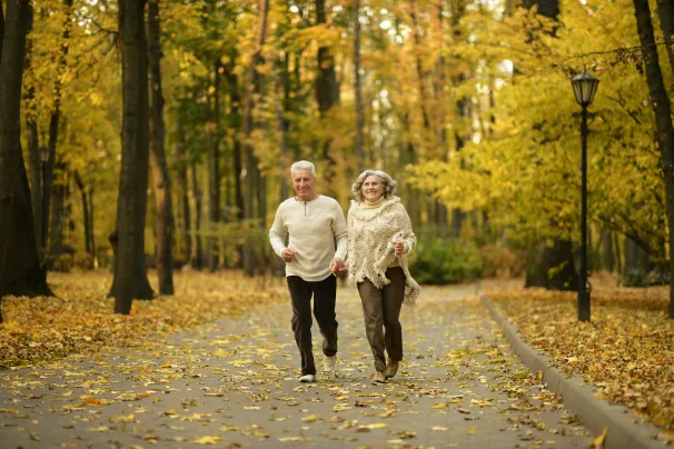 Two older people walking in a forest