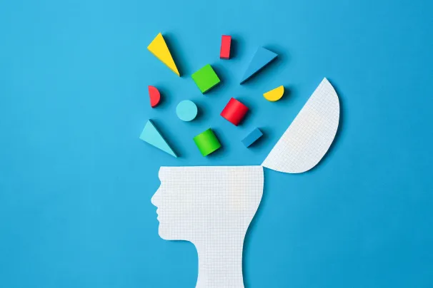 Silhouette of a head with coloured blocks representing ideas bursting out of the top